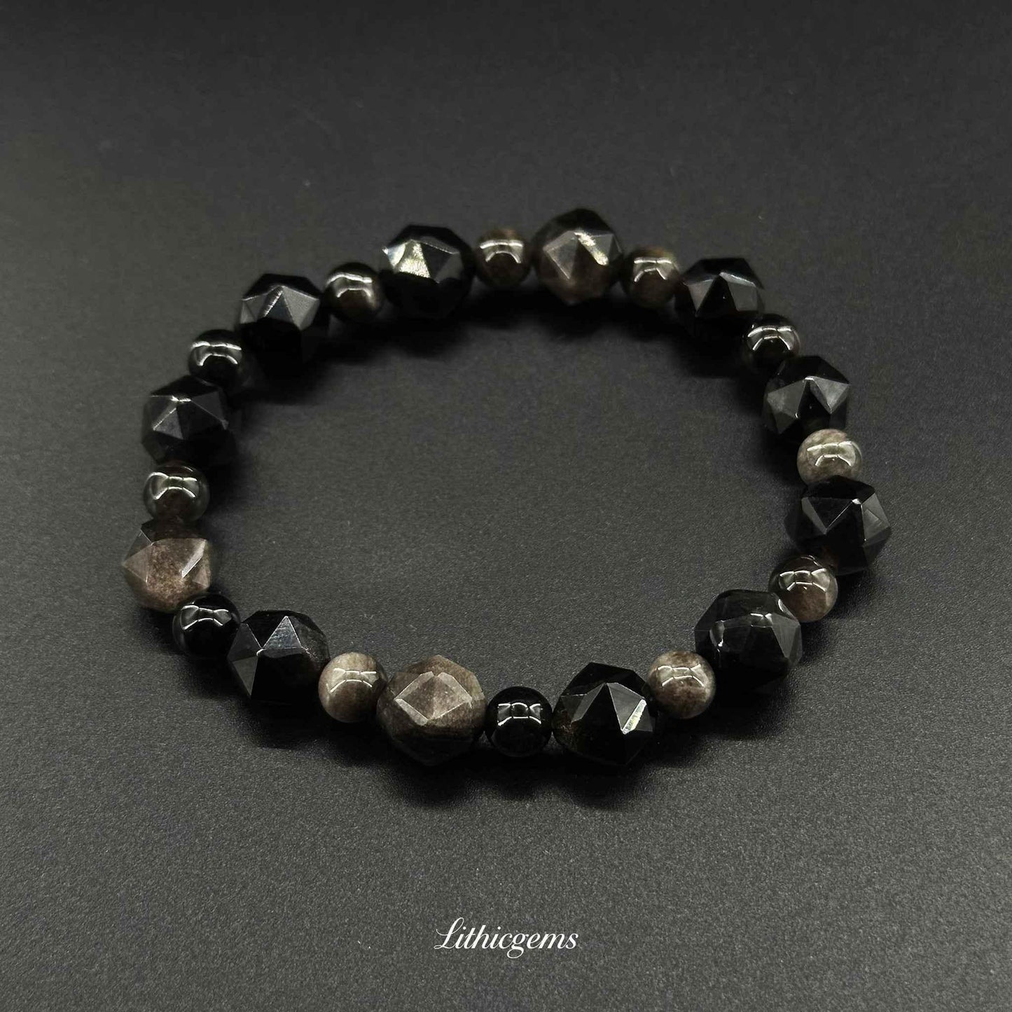Faceted black and brown gemstone beaded bracelet on black background, Lithicgems crystals.