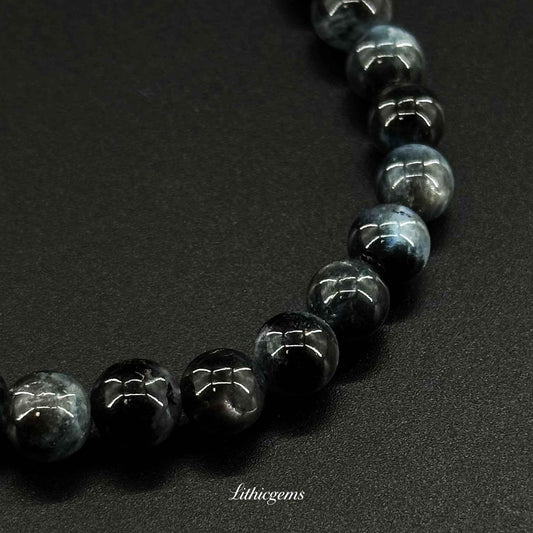 Polished blue and black gemstone bead bracelet on black background, Lithicgems crystal jewelry