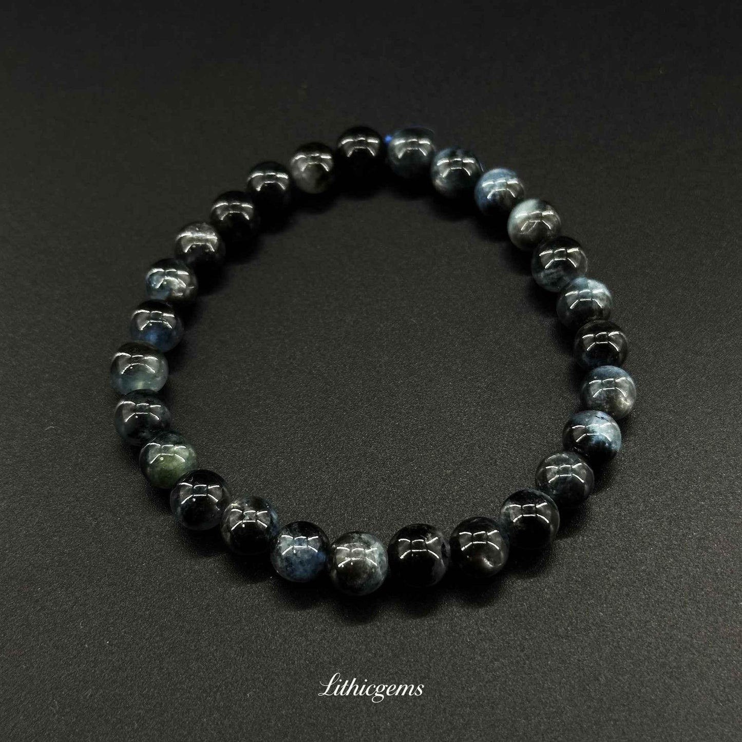 Dark blue and black crystal bead bracelet on black background, Lithicgems premium gemstone jewelry