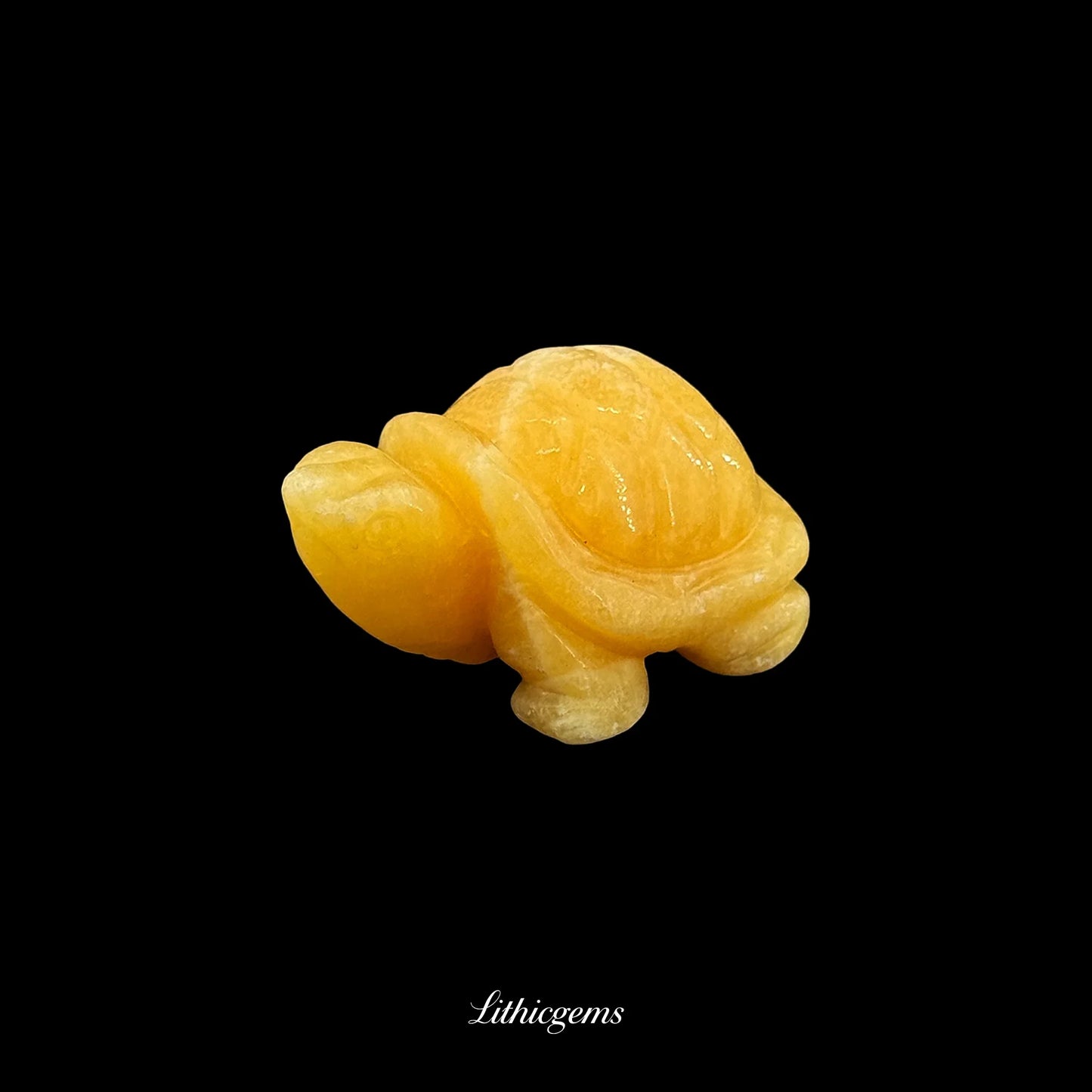 Yellow crystal turtle figurine from Lithicgems gemstone boutique on black background