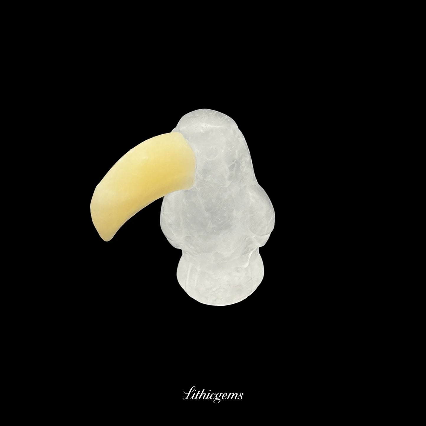 Clear crystal toucan figurine with yellow beak on black background, Lithicgems boutique