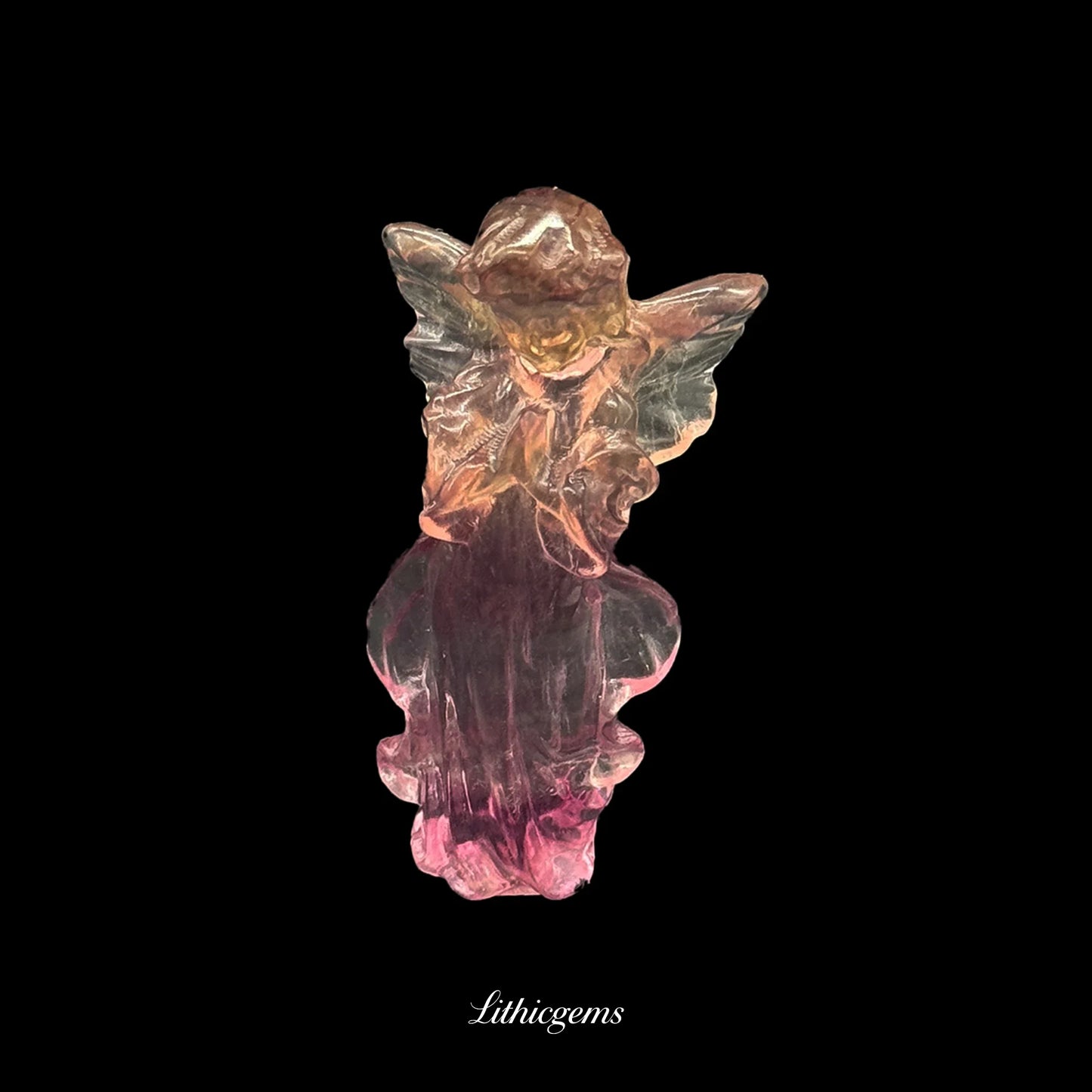 Hand-carved gemstone fairy figurine with pink and amber hues on black, Lithicgems boutique