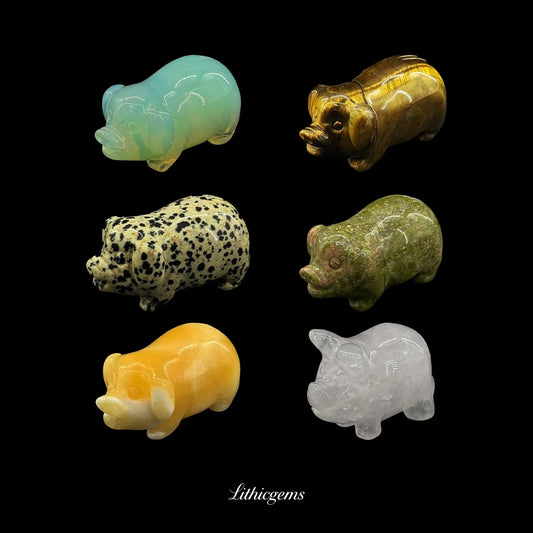 Assorted crystal and gemstone pig carvings on black background, Lithicgems boutique collection