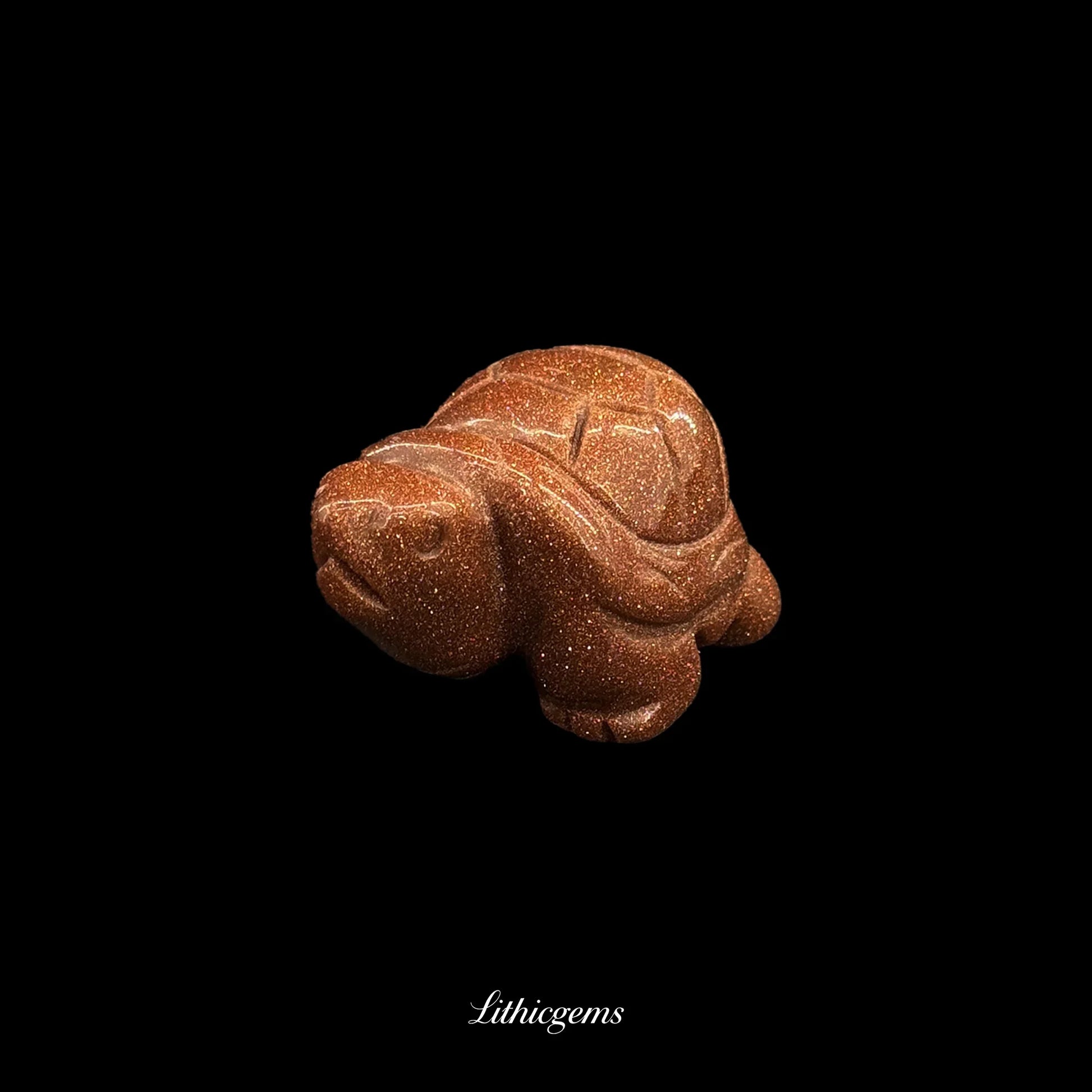 Goldstone crystal turtle figurine on black background, Lithicgems boutique